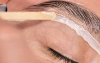 Eyebrow Shaping: Waxing vs Threading. Image of an eyebrow wax for our beauty blog post about brow waxing vs brow threading.